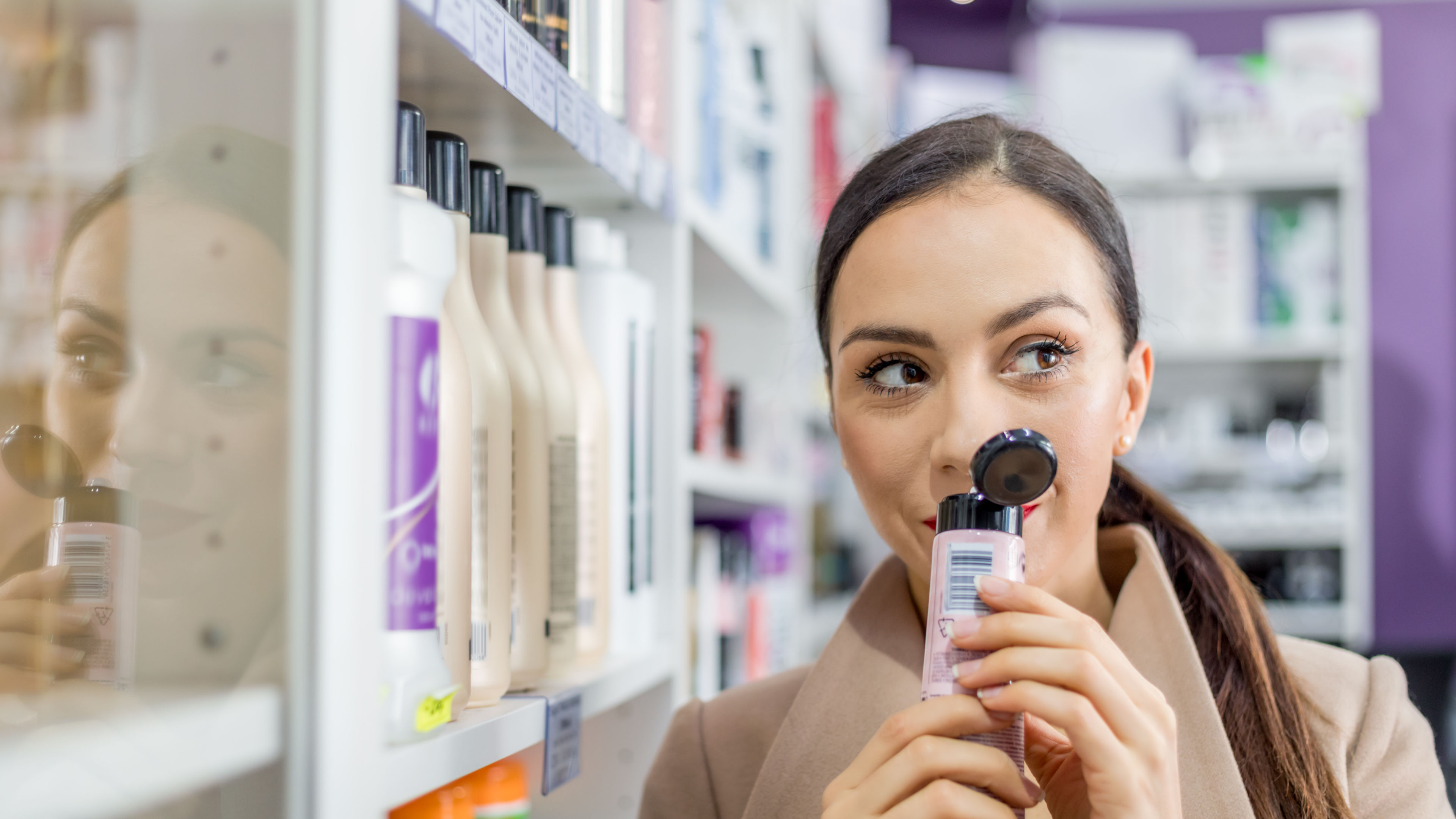 Smiling woman in cosmetic store looking for beauty skin care products