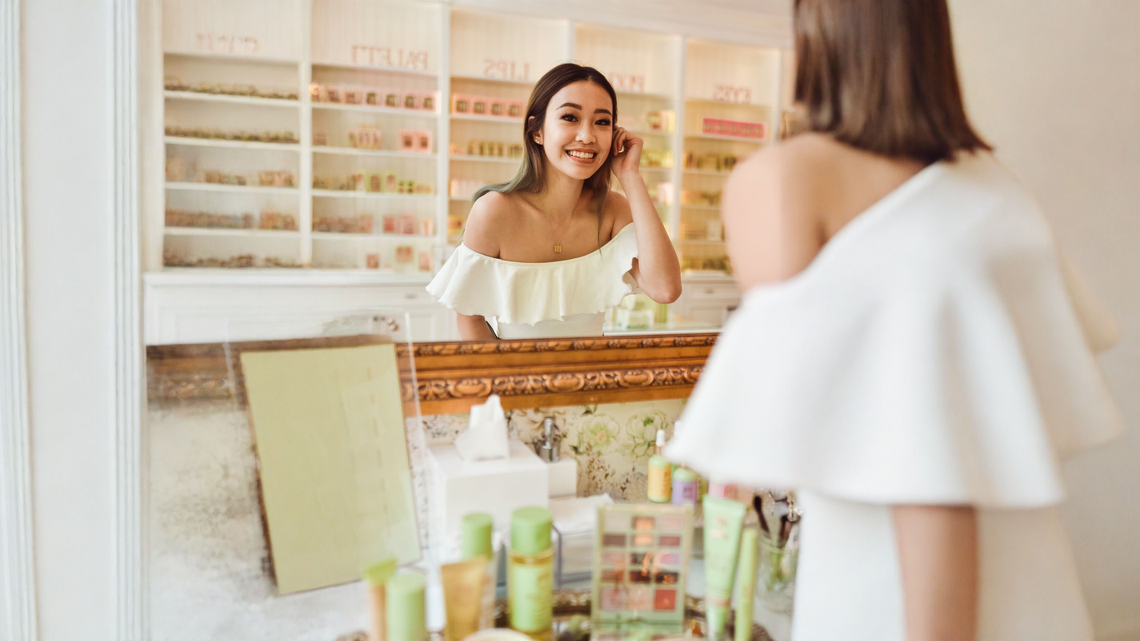 Young beautiful woman standing infront of a mirror in beauty shop.