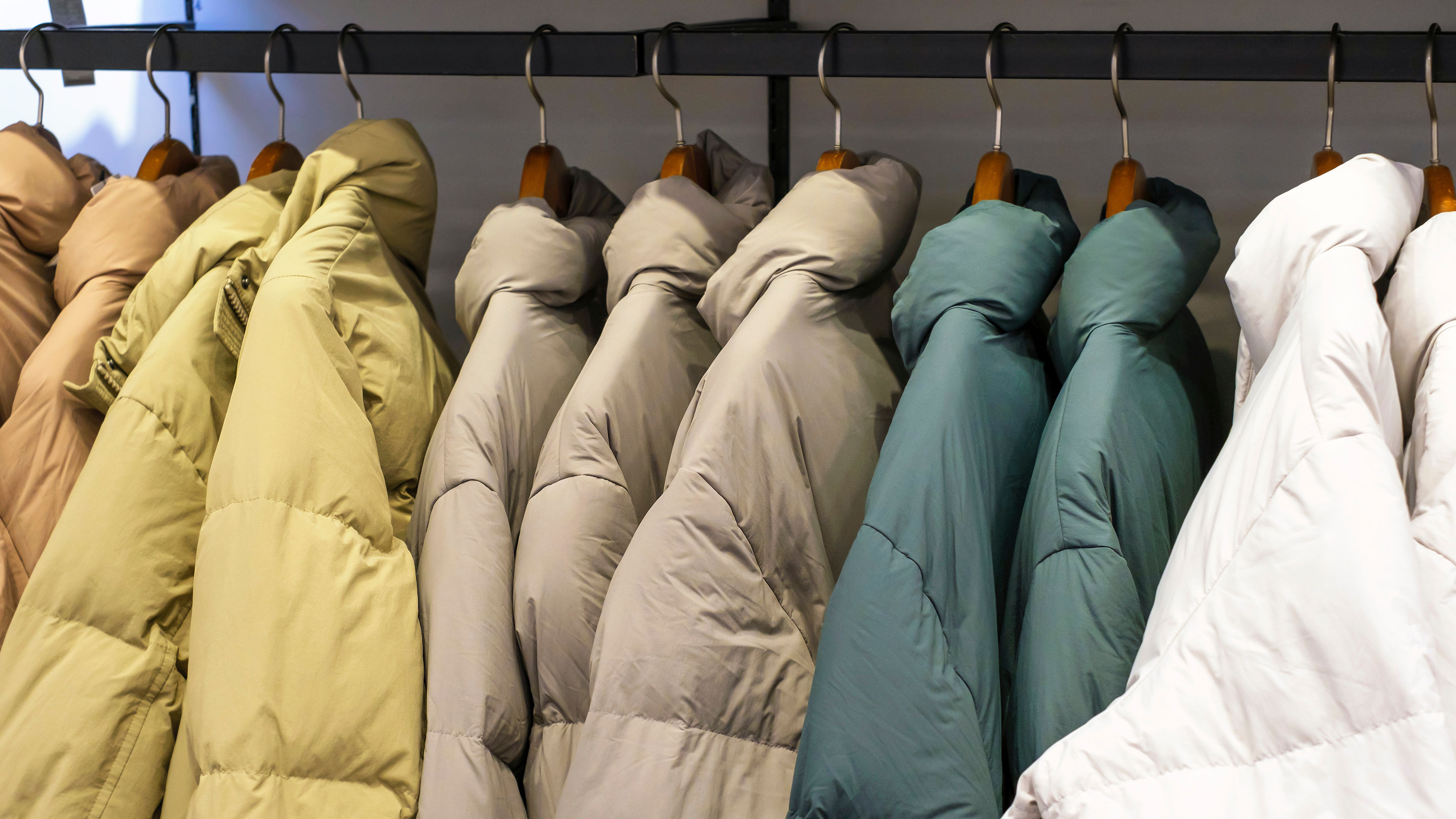 A clothing rack displays several thick, puffy jackets