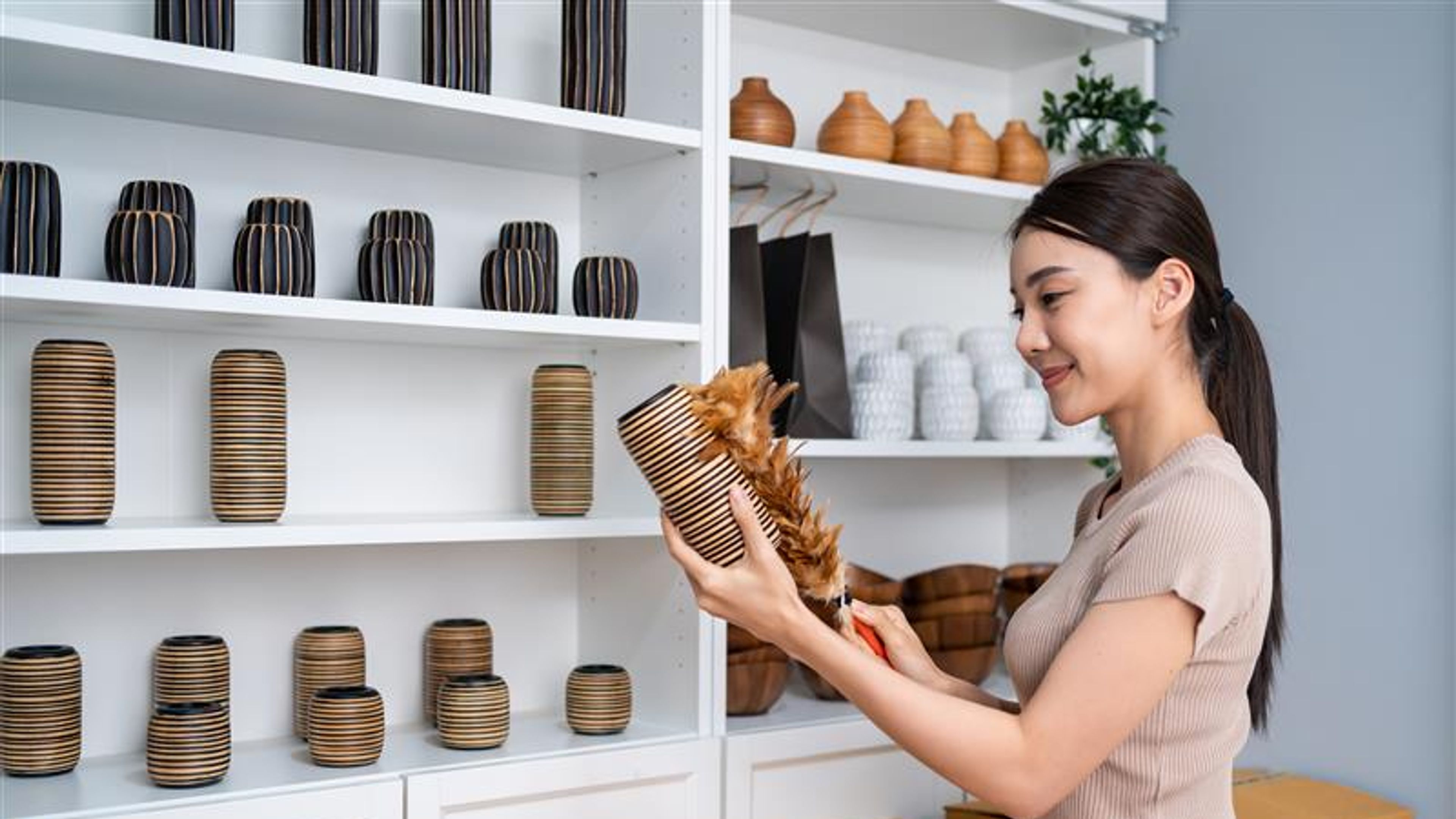A woman holding a vase in hand