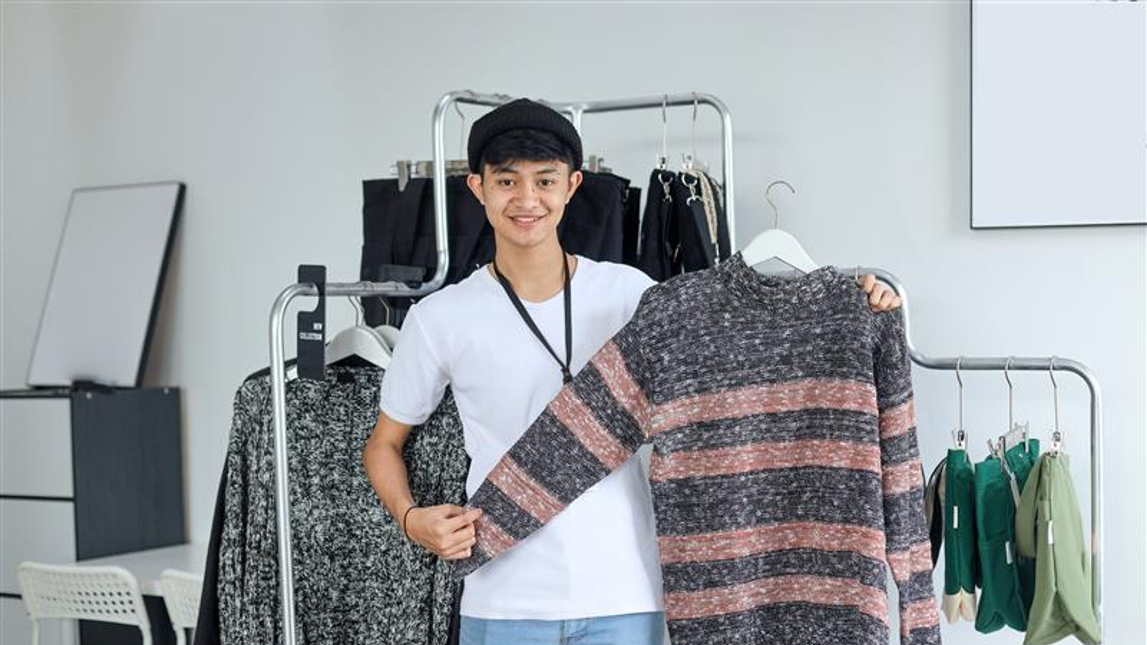 Asian clothing shop staff showing the items to camera